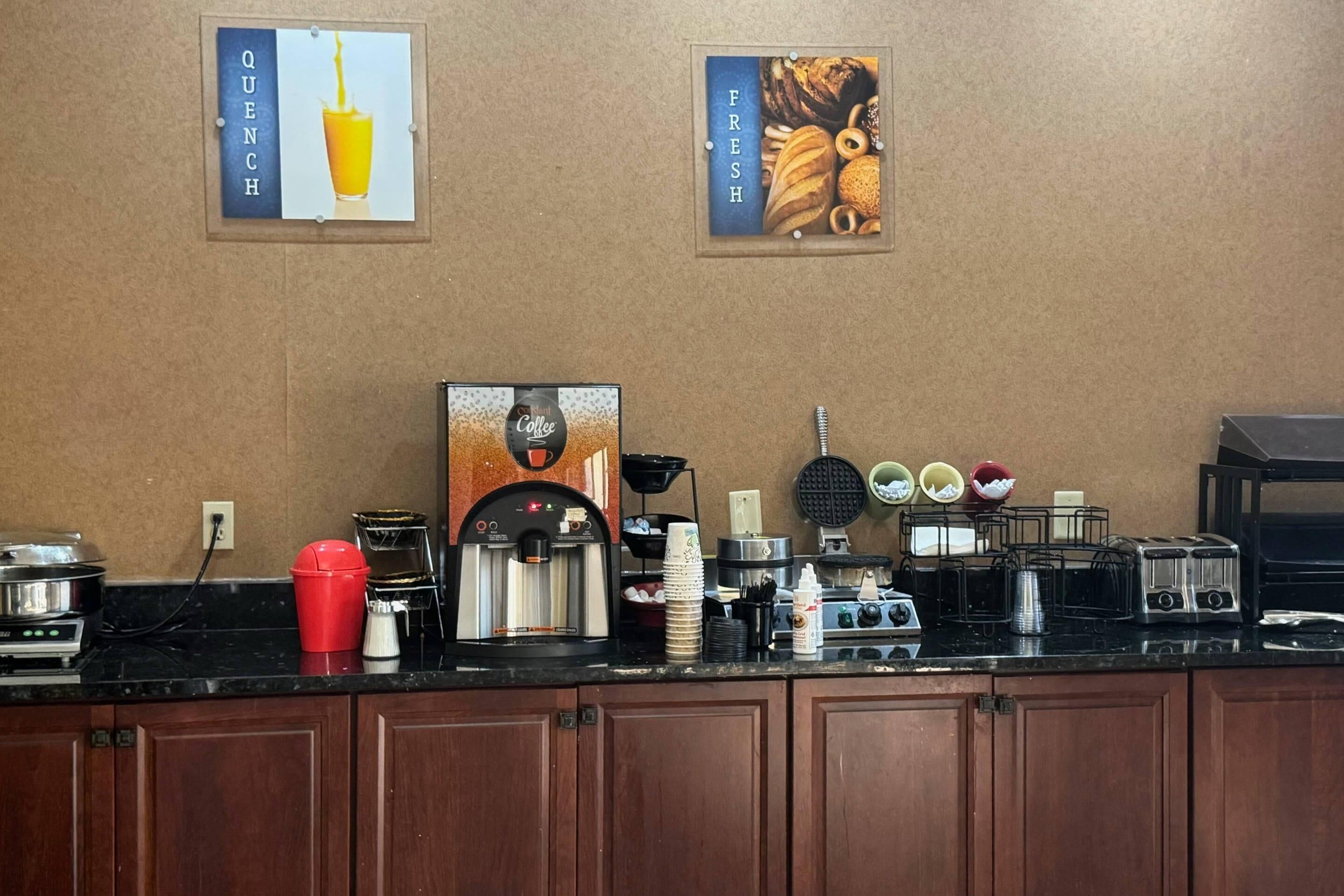 Un coin café équipé d’une machine à café, de tasses et d’un appareil à gaufres.