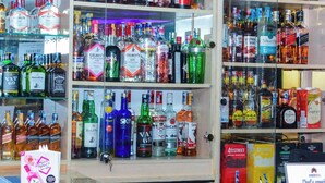 Una licorería con estantes repletos de botellas de licores varios.