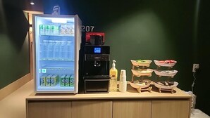A refrigerator stocked with beverages, a coffee machine, and a snack bar with bowls. - Brown Dot Hotel NamGumi (Chilgok)