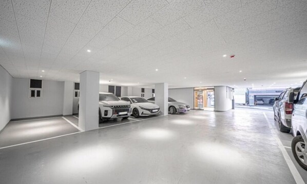 A modern parking garage with white walls and a polished concrete floor. - Brown Dot Hotel NamGumi (Chilgok)