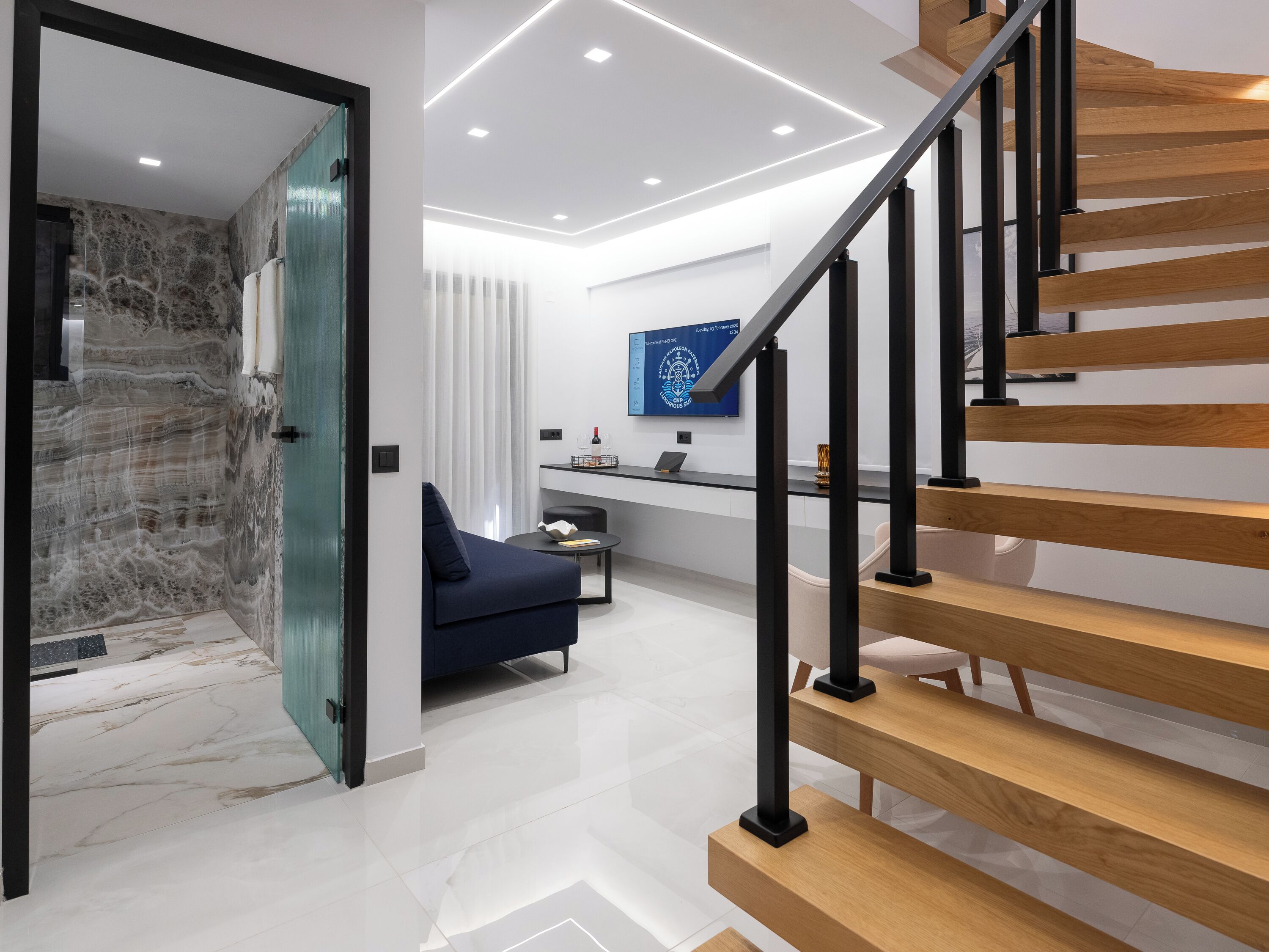 Un intérieur moderne avec un escalier, un canapé et un espace bureau.