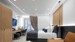 Una habitación de hotel moderna con cama, escritorio, silla, mesa redonda y televisor.