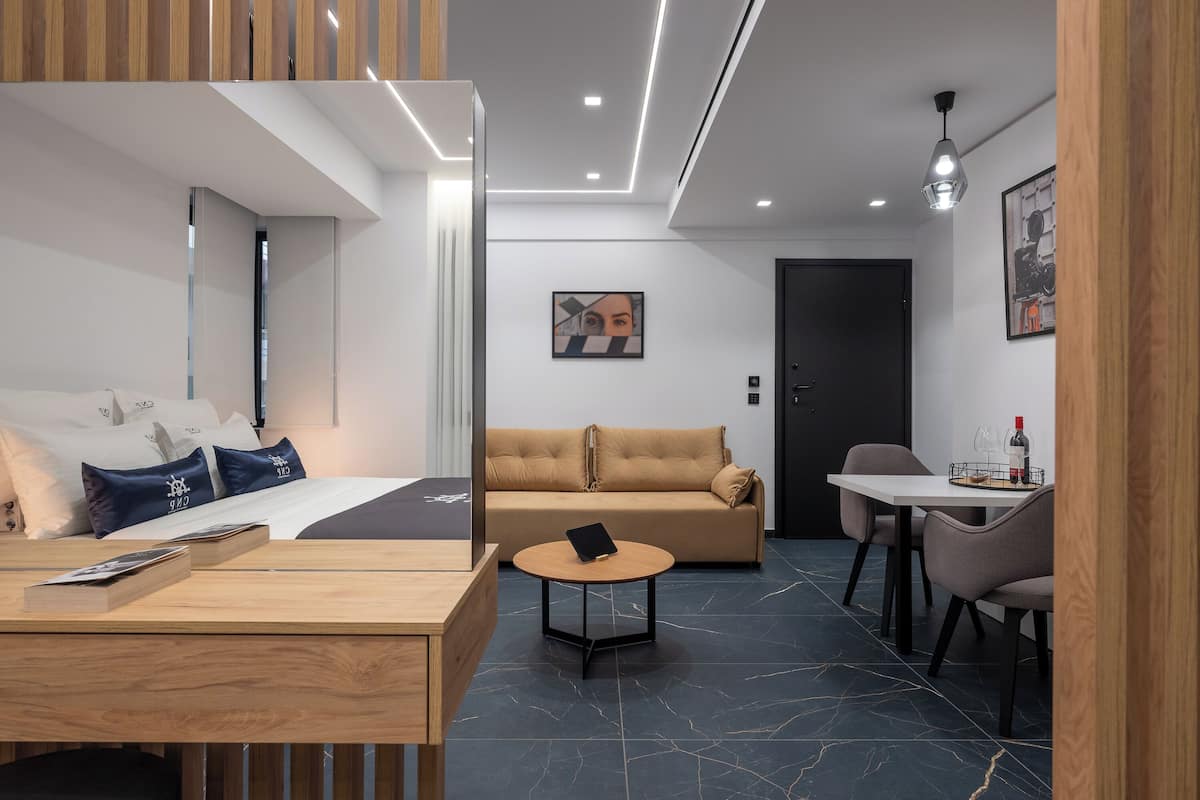 Une chambre d’hôtel moderne équipée d’un lit, d’un canapé, d’une table à manger et d’un petit coin cuisine.
