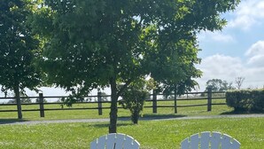 Two white Adirondack chairs with American flag cushions on a grassy field. - Le Clos du Bas Courtil (Osmanville)