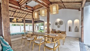 A spacious outdoor dining area with wooden furniture and a thatched roof. - Central Canggu Walk to Nelayan Beach - 3BR Villa (kuta utara)