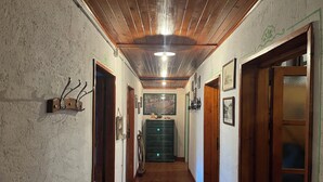Ein Flur mit Holzboden und -wänden, einem grünen Schrank und gerahmten Bildern.