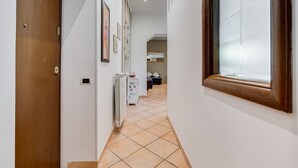 A hallway with a wooden door, a radiator, and a window with blinds. - Villa Riccio-Flaminio House (Roma)