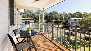 A balcony with a table and chairs, a ceiling fan, and a view of the neighborhood. - Smart Suites Self Check-in Apartments - 19 Darnley (Rocklea)