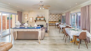 A dining area with a central island, chairs, and tables set for dining.
