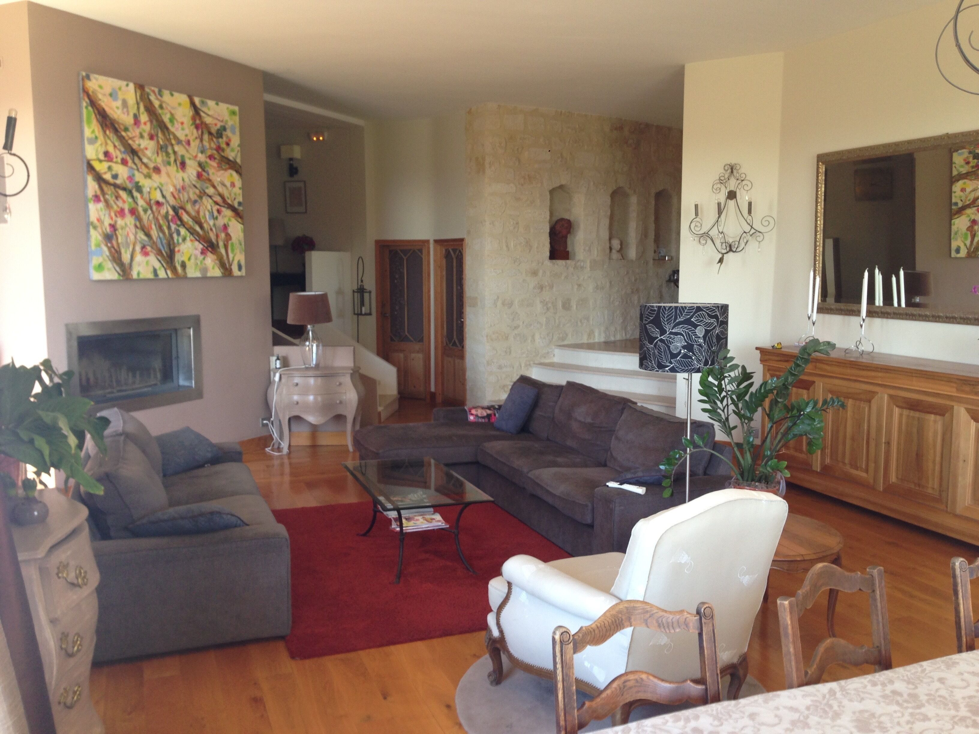 A living room with a fireplace, a sofa, a coffee table, and a dining area with a table and chairs.