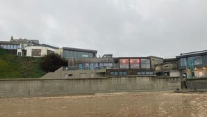 A coastal building with a modern design, featuring large windows and a flat roof. - Luxury caravan, Newquay Bay. Amazing views. (Newquay )