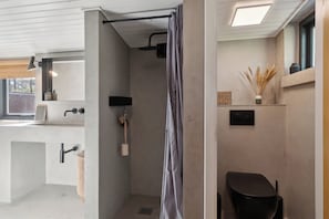 A modern bathroom with a shower, toilet, and sink.