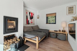 Un cuarto acogedor con cama, chimenea, ventana y una obra de arte colgada en la pared.