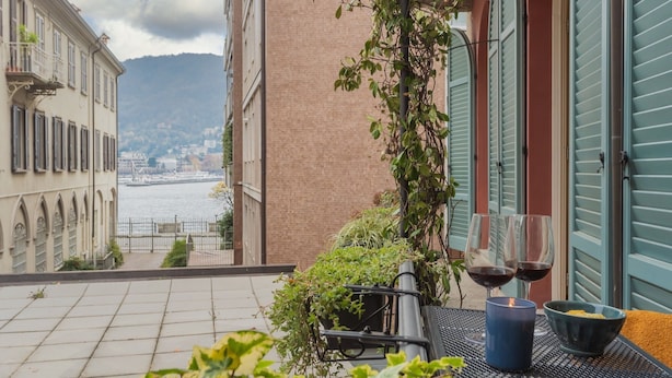 A terrace with a view of the sea, a table with two glasses of red wine, and a candle. - The Printers Home 2 by Rent all Como (Como)