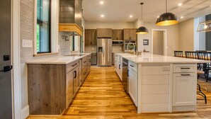 A modern kitchen with wooden cabinets, stainless steel appliances, and a central island. - Family House on Watauga River (Johnson City)