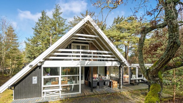 A cabin with a sloped roof, large windows, and a deck area. - "Poul" - 1.9km from the sea by Interhome (Blåvand)