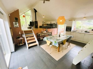 Una cocina moderna con comedor, una escalera y vistas al exterior.