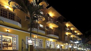 A multi-story hotel with balconies, a bar, and a fenced courtyard. - Hotel Grand Image Inn (Calangute)