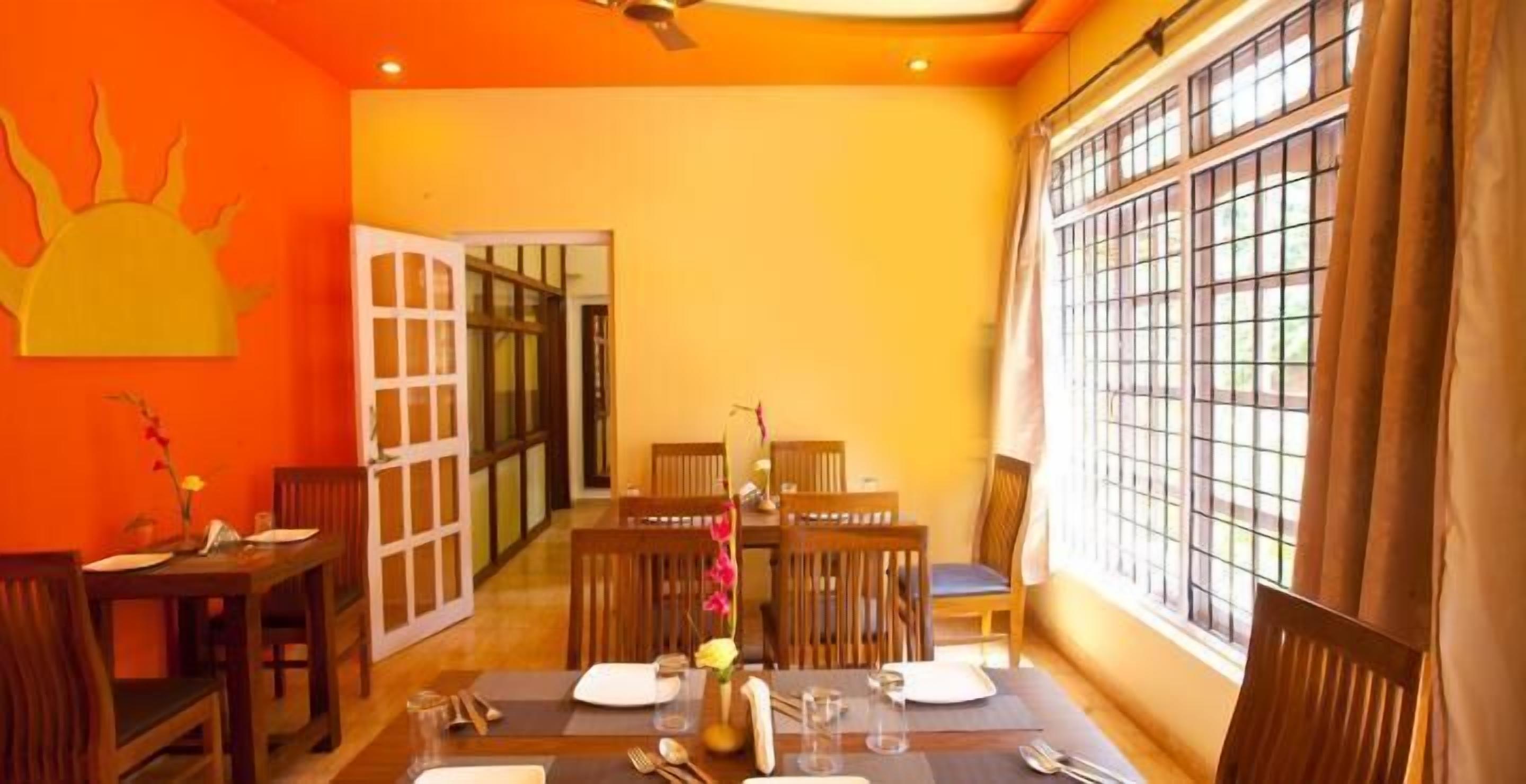 A dining area with a table set for four, wooden chairs, and a window with metal bars.