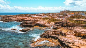 A coastal town with rocky terrain and clear blue waters. - Dimora Cala Graziosa (Favignana)