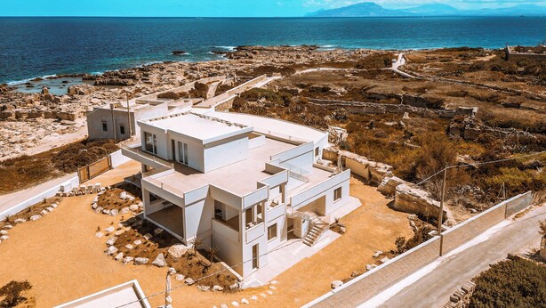 A modern two-story house with a flat roof, located near a rocky coastline with a view of the sea. - Dimora Cala Graziosa (Favignana)