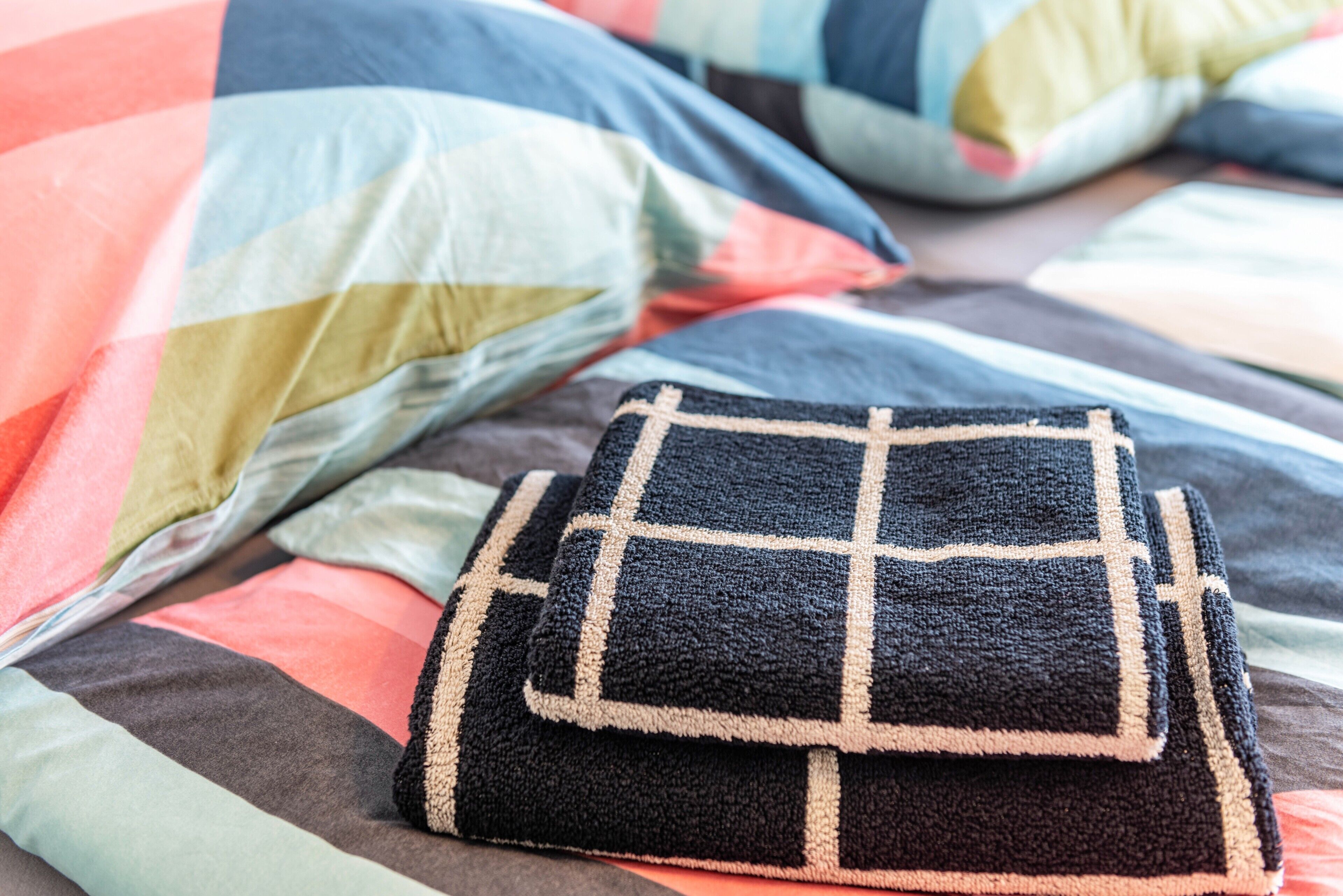 Een bed met een bed met een patroon erop en kussens.