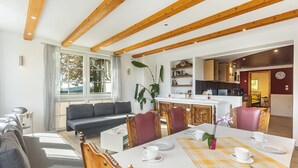 A dining area with a table set for four, a sofa, and a kitchen in the background. - Apartment 'Nr 4' with Shared Garden and Wi-Fi (Kirchhundem)