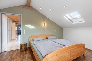 A bedroom with a skylight, wooden bed, and a view of a hallway. - Apartment 'Haus Eckert' with Balcony and Wi-Fi (Höchenschwand)