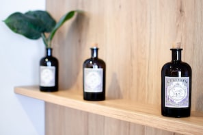 Three bottles of alcohol on a wooden shelf.