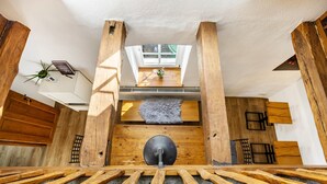 Un intérieur en bois avec une porte centrale, une petite fenêtre et une plante accrochée au mur.