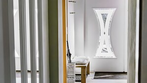 A hallway with a patterned rug, a bench, and a decorative wall piece. - Holiday Apartment 'Waldfeeling' with Private Terrace and Wi-Fi (Brilon)