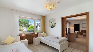 Une chambre d’hôtel avec deux lits, une fenêtre avec des rideaux, un miroir et une vue sur l’extérieur.