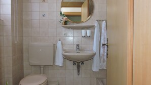 Ein Badezimmer mit Toilette, Waschbecken, Spiegel und Handtuchhalter.