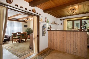 Un interior de madera con zona de comedor, una encimera de cocina y vistas a través de una ventana.