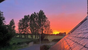 A rural landscape with a road, trees, and a sunset. - Bed and breakfast in Cotentin near shops, beaches and greenway. (Port-Bail-sur-Mer)