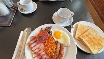 Desayuno con platos de huevos, frijoles, salchichas y tostadas.