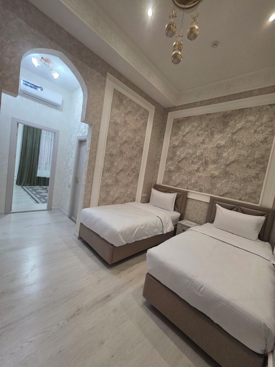 Une chambre d’hôtel avec deux lits, un grand miroir et une vue sur l’extérieur.