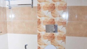 Een badkamer met toilet, handgreep en douche.