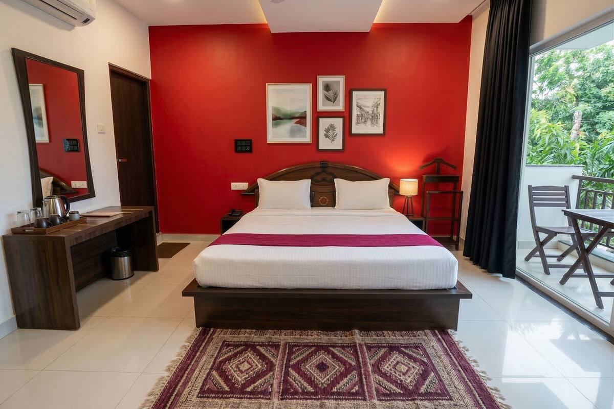 Ein Hotelzimmer mit Bett, Nachttisch, Lampe und Blick auf Grün.