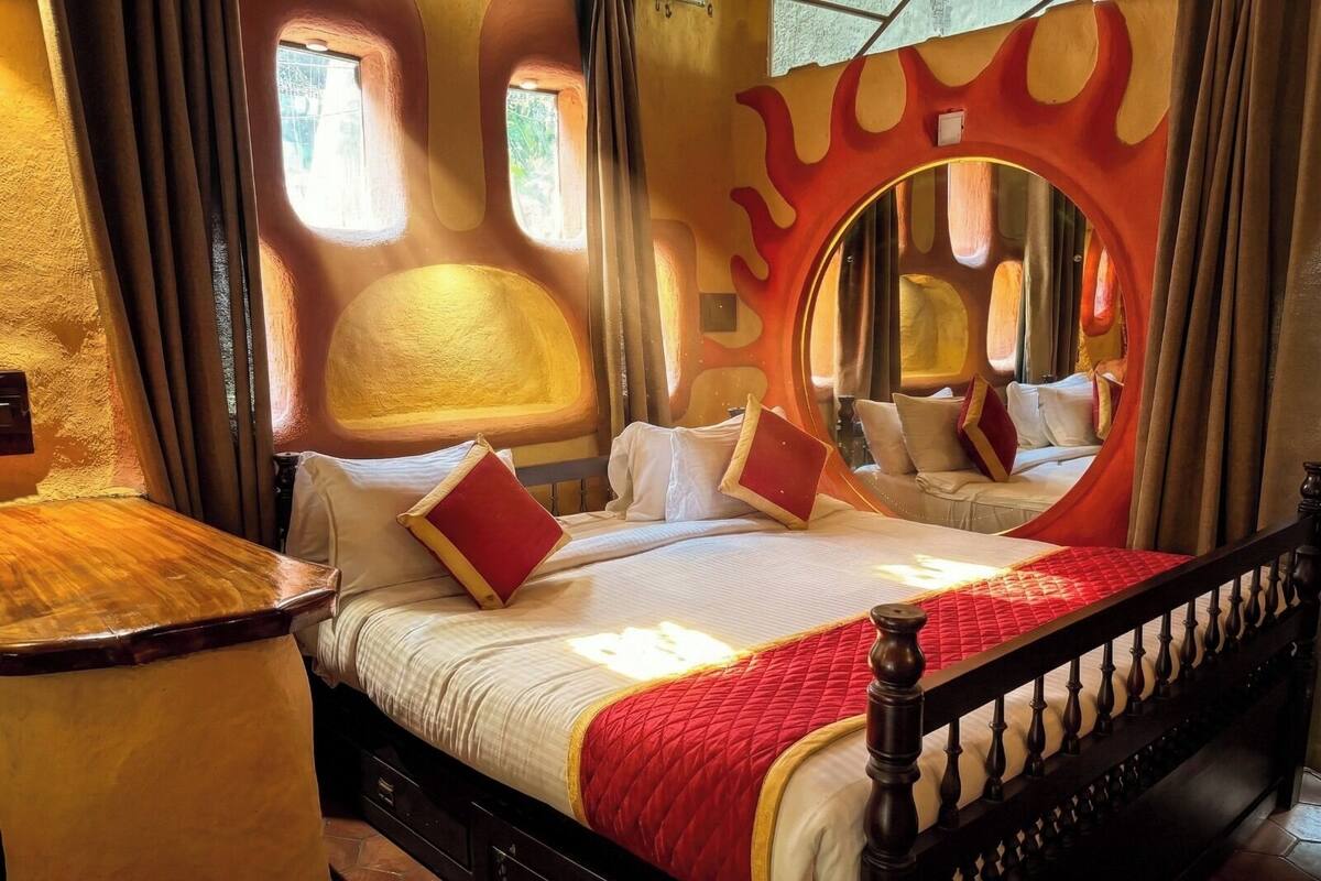 Ein Schlafzimmer mit einem großen Bett, einem Spiegel und einem außergewöhnlichen Wanddesign.