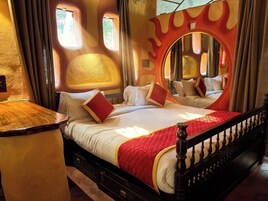 Un dormitorio con una cama grande, un espejo y un diseño de pared original.