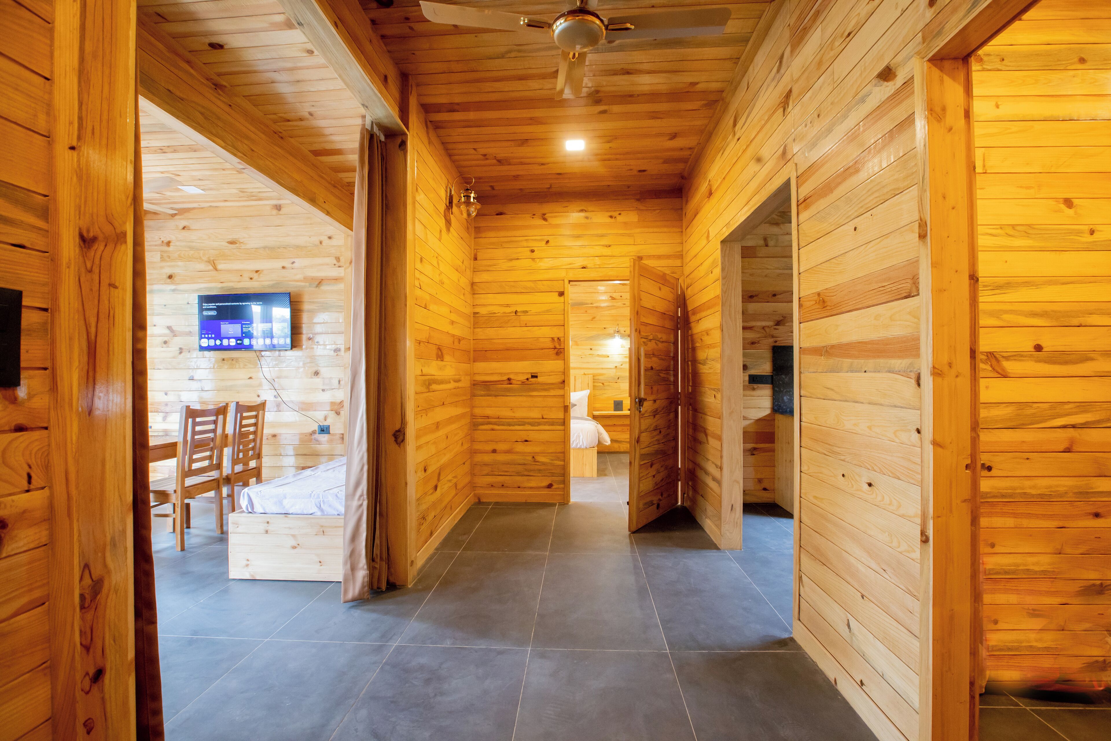 Une pièce avec un intérieur en bois, comprenant un lit, un bureau et un téléviseur.
