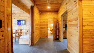 Une pièce avec un intérieur en bois, comprenant un lit, un bureau et un téléviseur.