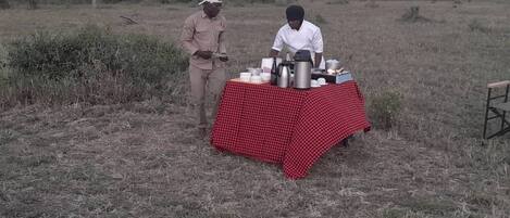 Una mesa con diversos objetos en un campo abierto.