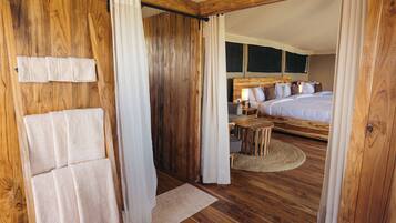 Una habitación de madera con una cama, una mesita y una silla.