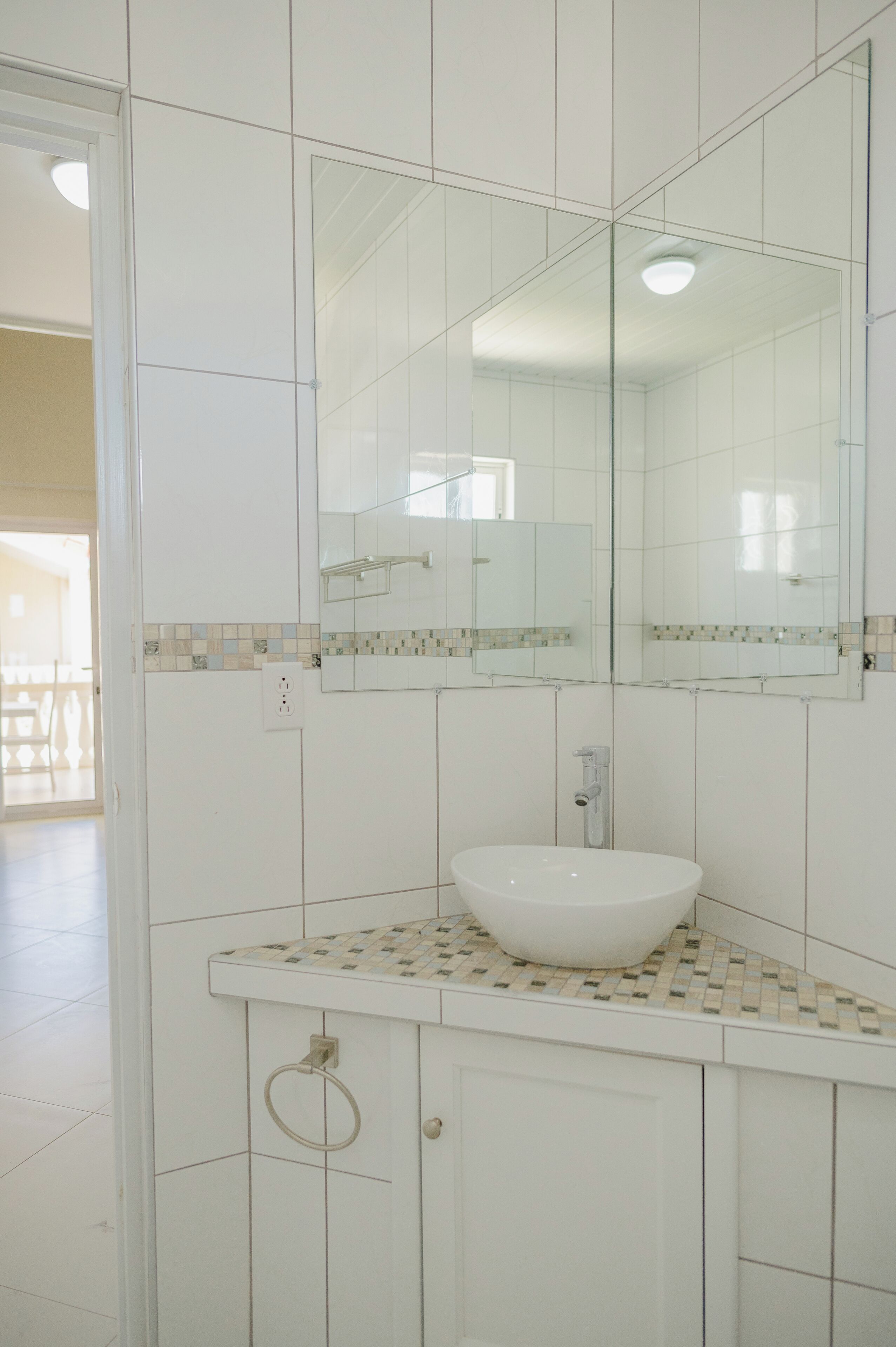 A bathroom with a white sink, a mirror, and a tiled backsplash.