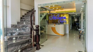 A hotel reception area with a marble staircase and a modern reception desk. - Melyna Hotel Nha Trang Beach (Nha Trang)