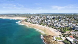 An aerial view of a coastal city with a beach, high-rise buildings, and a stadium. - Oceanic Views at Kings Beach - 300m to the beach (Caloundra Region)