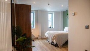 Une chambre à coucher moderne avec un lit, un grand miroir et une plante en pot.