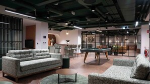 Un espace de détente moderne avec des canapés, une table de billard et un bar.